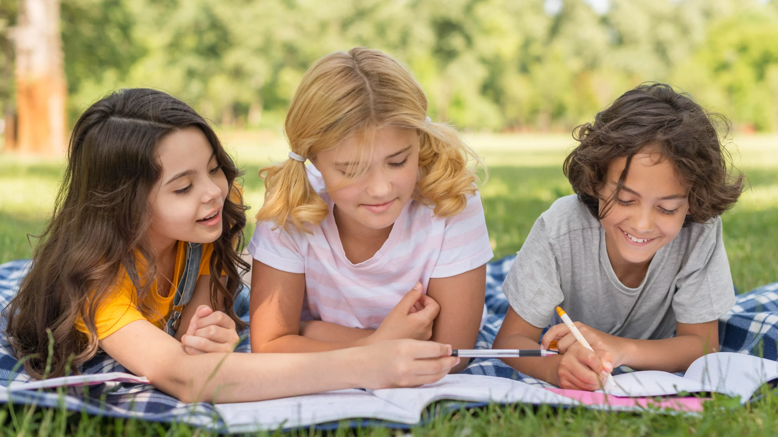 Children writing at a park